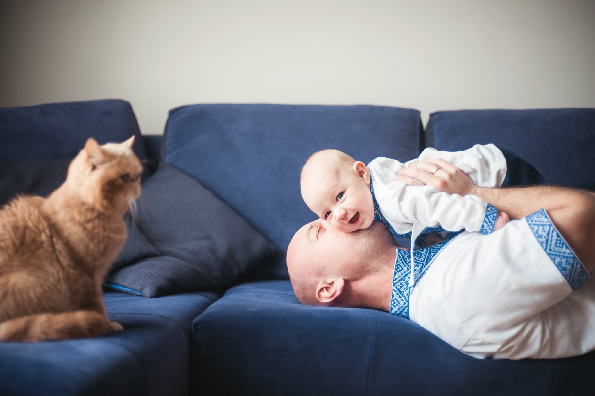 Tata i niemowlę na sofie obok kota — Fotogłos