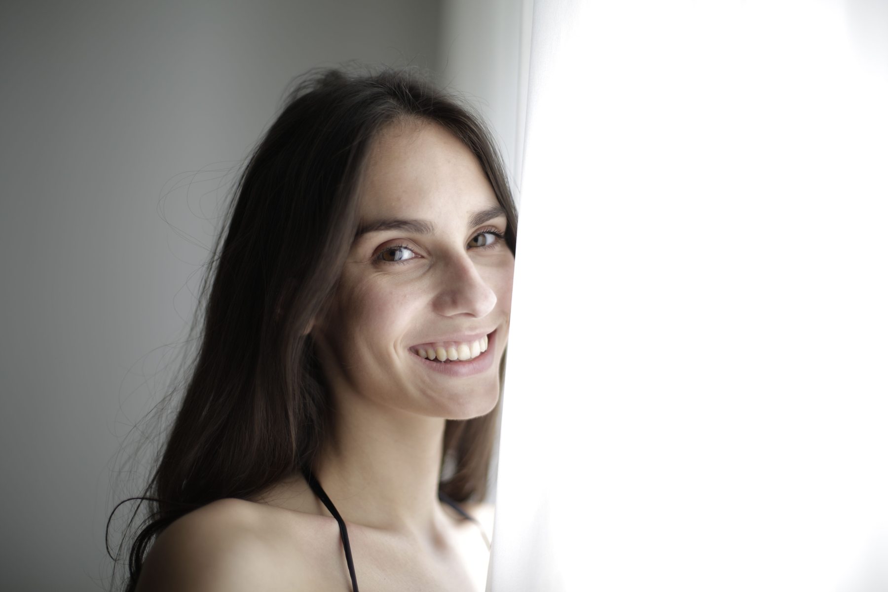 Naturalny portret kobiety przy oknie — zdjęcie poglądowe, nie realizacja Fotogłosu